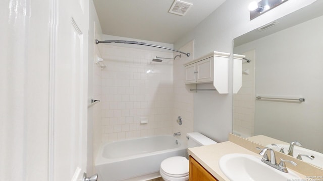 full bathroom featuring vanity, tiled shower / bath combo, and toilet