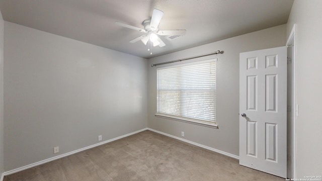 empty room featuring light colored carpet and ceiling fan