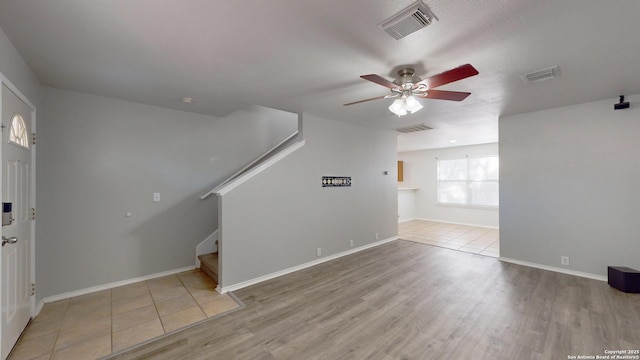 unfurnished living room with ceiling fan and light hardwood / wood-style floors