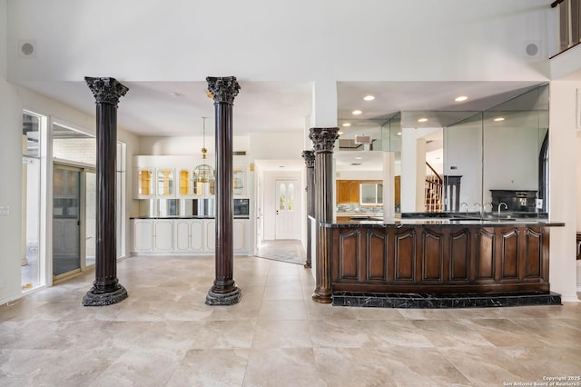 kitchen with dark brown cabinets and decorative columns