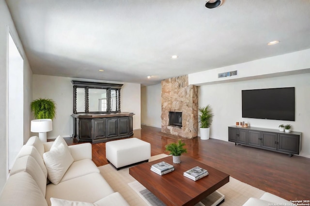 living room featuring a fireplace, light hardwood / wood-style floors, and a healthy amount of sunlight