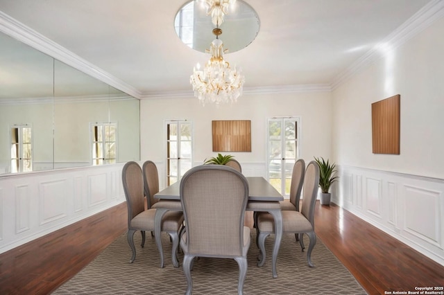 dining room featuring hardwood / wood-style flooring, crown molding, and an inviting chandelier