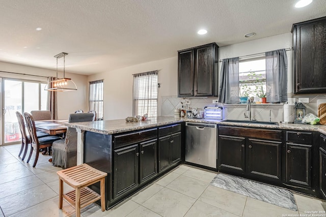 kitchen with kitchen peninsula, tasteful backsplash, sink, decorative light fixtures, and dishwasher