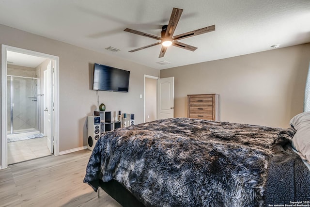 bedroom featuring light hardwood / wood-style flooring, ensuite bath, and ceiling fan