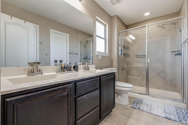 bathroom featuring a shower with door, vanity, and toilet