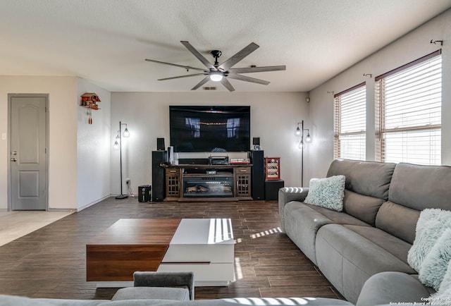 living room featuring ceiling fan and a textured ceiling