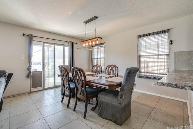 dining room featuring a notable chandelier, light tile patterned flooring, and a textured ceiling