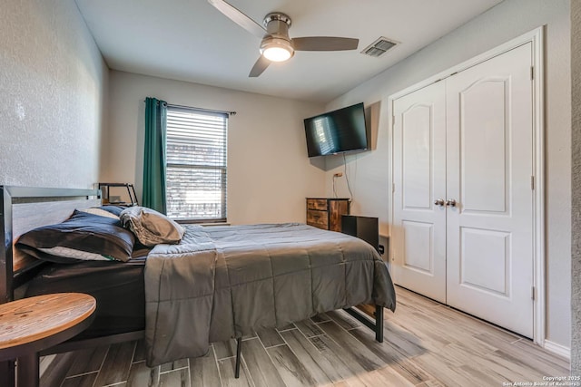 bedroom featuring ceiling fan, a closet, and light wood-type flooring