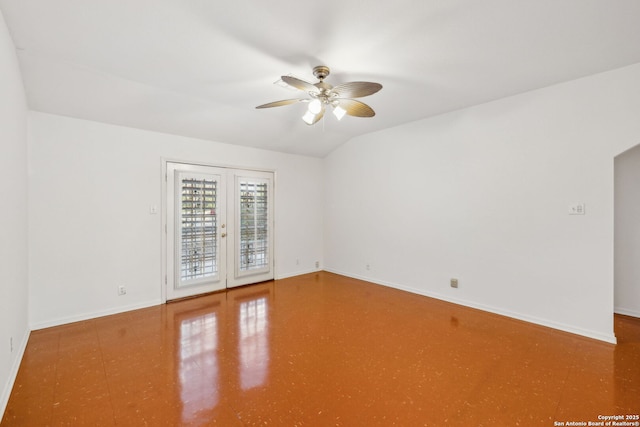 empty room featuring ceiling fan, vaulted ceiling, and french doors