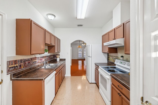 kitchen featuring decorative backsplash, sink, and white appliances