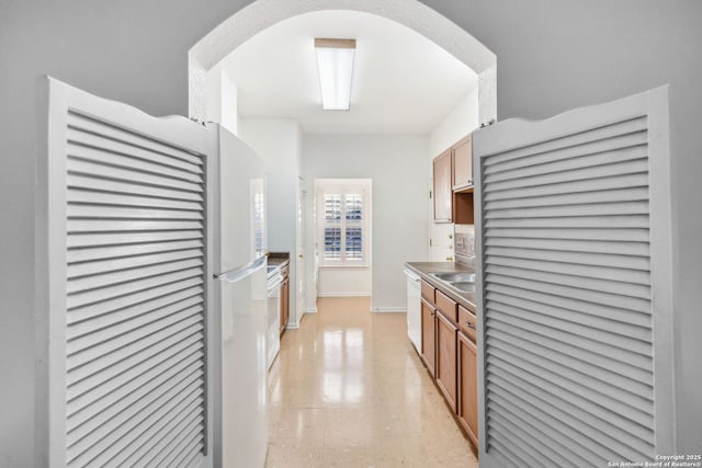 kitchen featuring white dishwasher, fridge, and sink