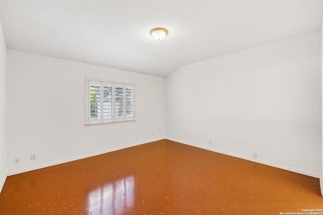 empty room featuring vaulted ceiling