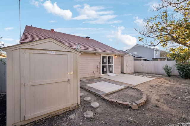 rear view of house with a patio and a storage unit