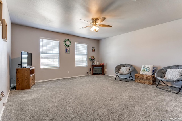 living area featuring ceiling fan and carpet