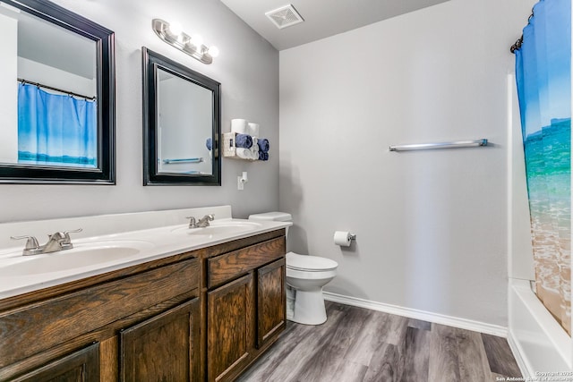 full bathroom featuring hardwood / wood-style floors, vanity, toilet, and shower / tub combo with curtain