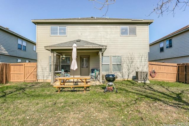 rear view of property with a lawn, a patio area, and central AC