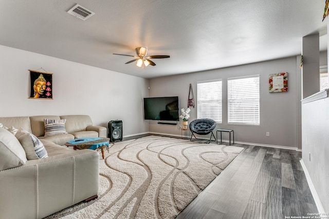 living room with wood-type flooring and ceiling fan