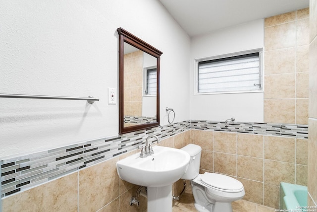 bathroom with decorative backsplash, tile walls, and toilet