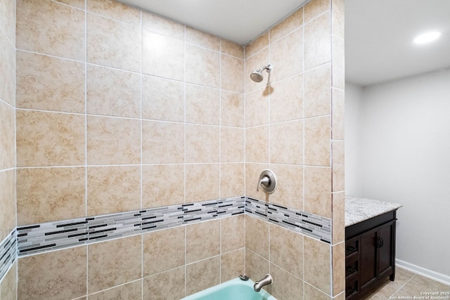 bathroom featuring tile patterned floors, vanity, and tiled shower / bath