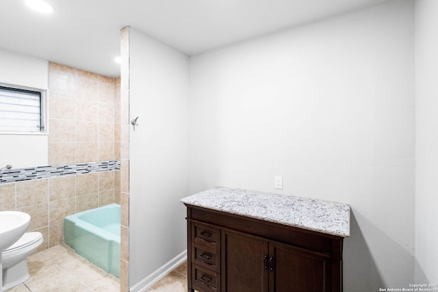 bathroom with tile patterned floors, a bathing tub, toilet, and tile walls