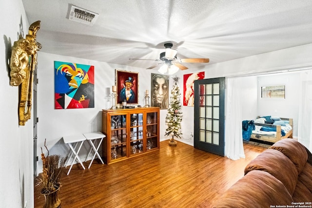 interior space featuring wood-type flooring, a textured ceiling, and ceiling fan