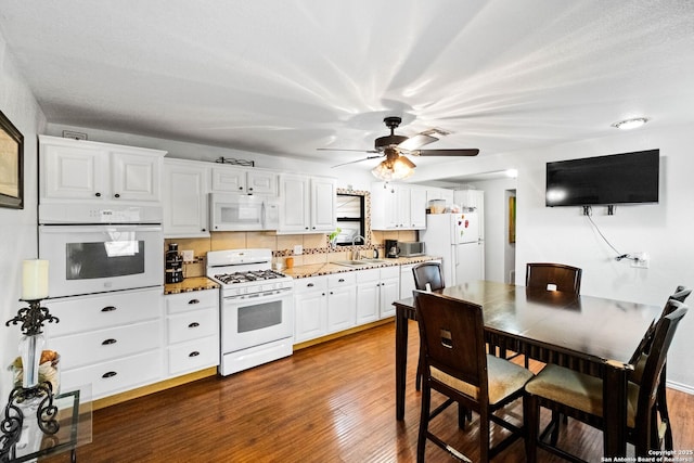 kitchen featuring decorative backsplash, sink, white cabinets, and white appliances