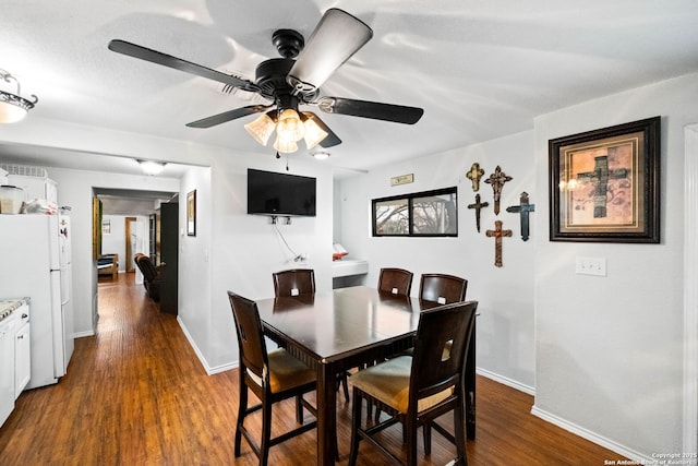 dining room with ceiling fan and dark hardwood / wood-style flooring