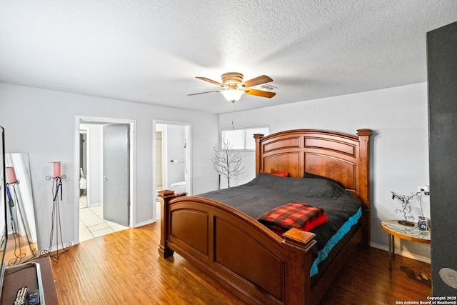 bedroom with a textured ceiling, light hardwood / wood-style flooring, ensuite bath, and ceiling fan