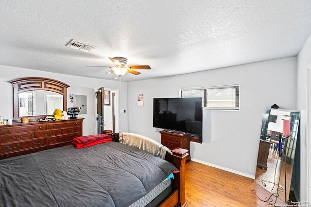 bedroom featuring ceiling fan, a textured ceiling, and hardwood / wood-style flooring