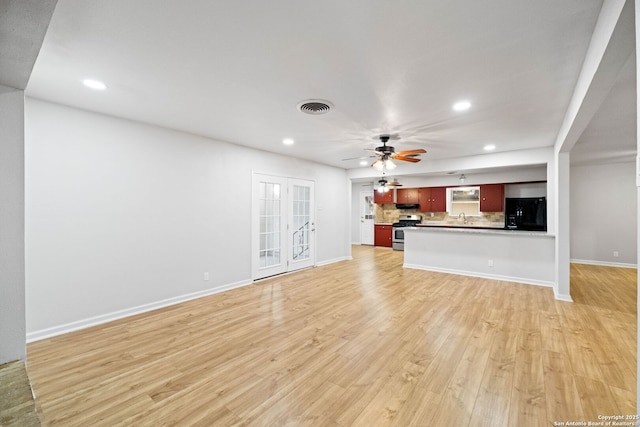 unfurnished living room with light hardwood / wood-style flooring and sink