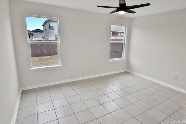 tiled spare room with ceiling fan