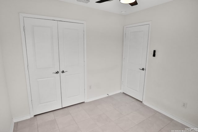 unfurnished bedroom with ceiling fan, a closet, and light tile patterned floors