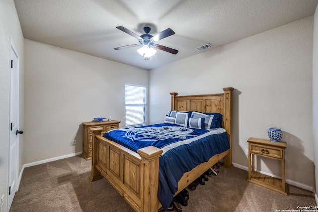 carpeted bedroom with ceiling fan and a textured ceiling