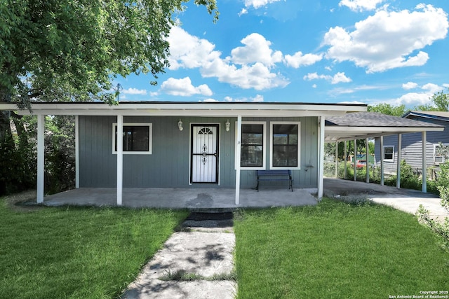 view of front of property with a front lawn, covered porch, and a carport