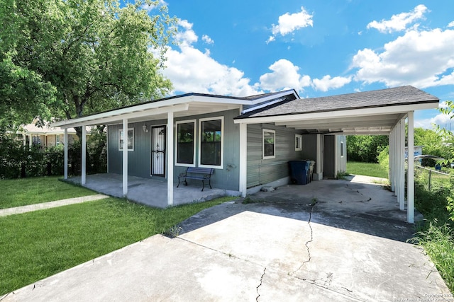 ranch-style house featuring a front lawn and a carport