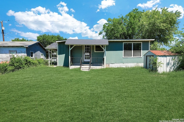 view of front of property featuring covered porch, a shed, and a front yard