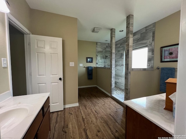 bathroom featuring a tile shower, vanity, and hardwood / wood-style flooring