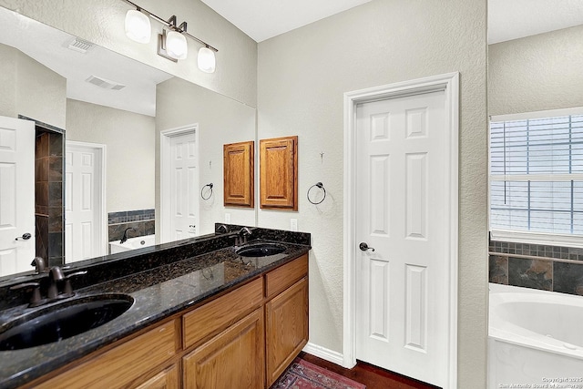 bathroom featuring vanity and a bath