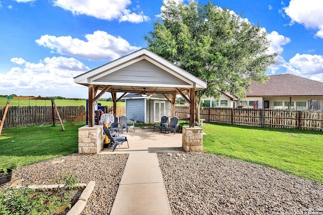 view of yard featuring a gazebo, a storage unit, ceiling fan, and a patio area