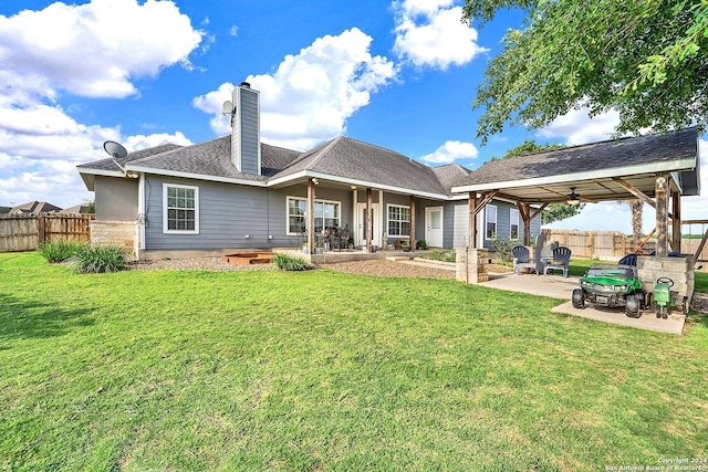 back of house with a yard and a patio