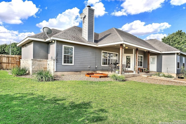 back of house featuring a lawn and a patio area