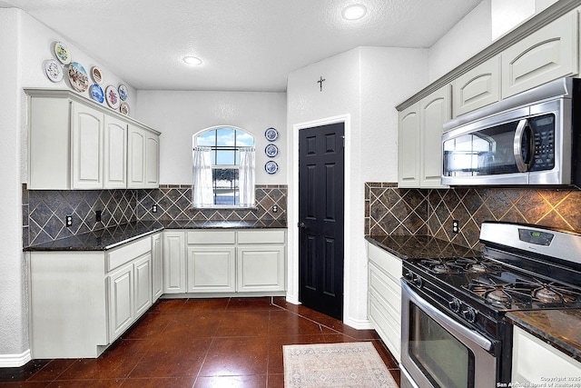 kitchen with backsplash, white cabinets, stainless steel appliances, and a textured ceiling