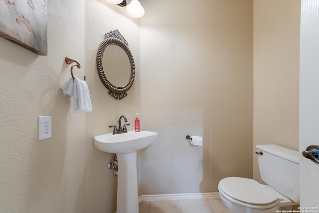 bathroom featuring tile patterned flooring, toilet, and sink