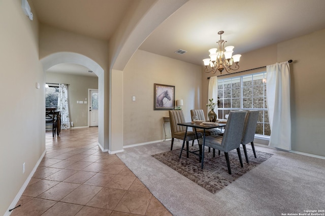 tiled dining area with plenty of natural light and a notable chandelier