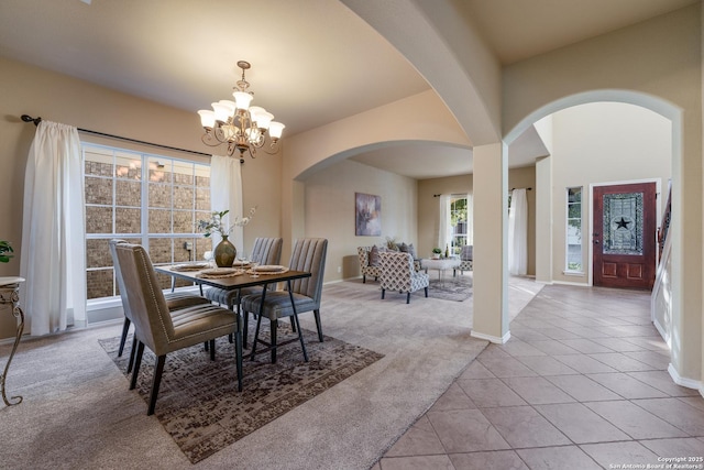 dining area featuring light carpet and a chandelier