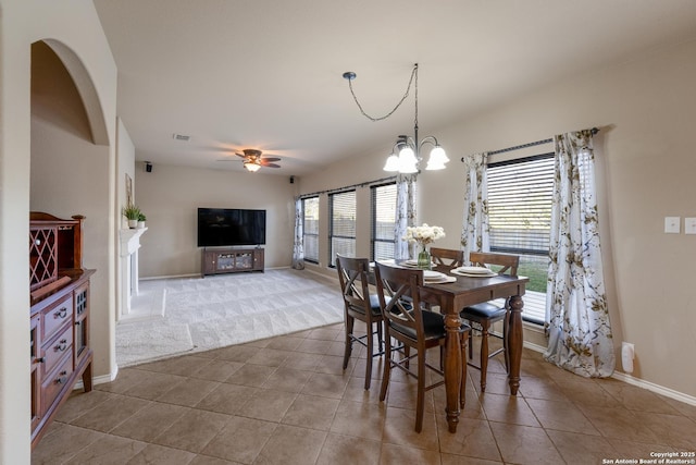 dining area featuring tile patterned floors and ceiling fan with notable chandelier