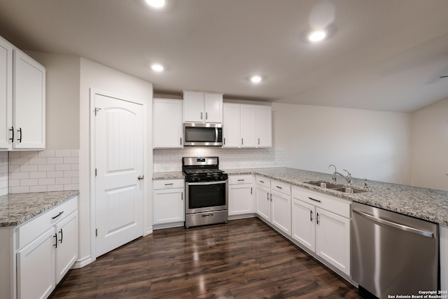 kitchen with kitchen peninsula, white cabinetry, sink, and stainless steel appliances