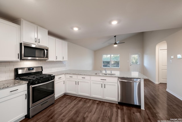 kitchen featuring lofted ceiling, white cabinets, sink, appliances with stainless steel finishes, and kitchen peninsula