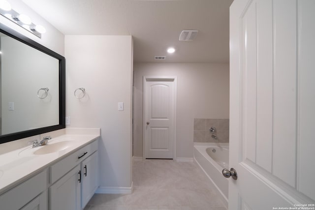 bathroom featuring tile patterned flooring, vanity, and a bath