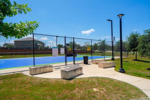 view of sport court featuring a lawn